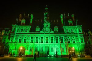 на снимката: сградата на кметството във френската столица беше осветена в зелено в знак на протест срещу решението на Доналд Тръмп