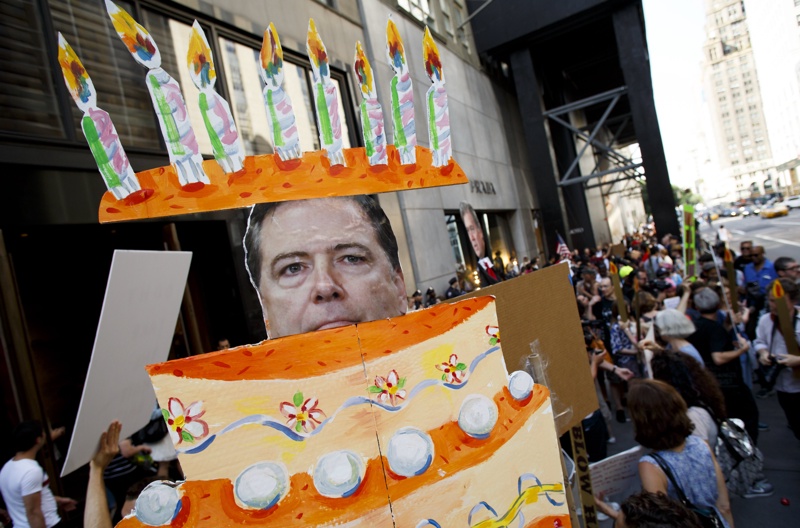 Протест на 14 юни пред "Тръмп Тауър"(Ню Йорк) - демонстранти носят плакат с лика на ексдиректора на ФБР Джеймс Коми като торта.