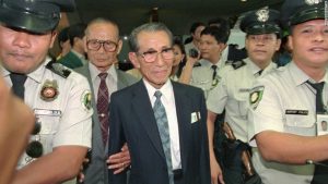 Former Japanese straggler Hiroo Onoda, center, is escorted by police shortly upon arrival in Manila Monday, May 20, 1996 for a sentimental journey. Onoda, then a lieutenant in the Japanese Army, stayed hidden in the island of Lubang, 90 miles southwest of Manila for 29 years until his discovery and subsequent surrender in 1974. Onoda will revisit his hiding place for the first time since emerging from his jungle hideout 22 years ago. (AP Photo/Bullit Marquez)