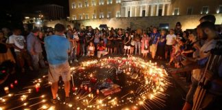 Със свещи в ръка и едноминутно мълчание стотици гърци почетоха паметта на загиналите си сънародници в унищожителните пожари к