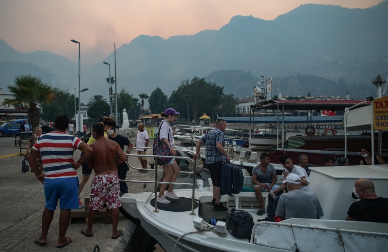 Туристи напускат Мармарис с лодка заради горските пожари в провинция Мугла, Турция, 01 август 2021г. 