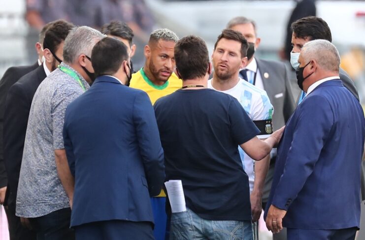 Неймар и Лионел Меси разговарят с бразилските здравни служители, след спирането на футболния мач между Бразилия и Аржентина
