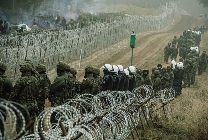 Полски войници, полицаи и служители на граничната охрана, охраняват оградата на границата близо до полско-беларуския граничен пункт в Кузница, 11 ноември 2021г.