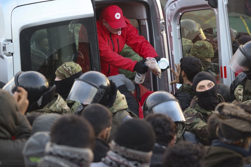 Служители на белоруския Червен кръст раздават храна на мигрантите, които се събират на границата между Беларус и Полша, 12 ноември 2021г. 