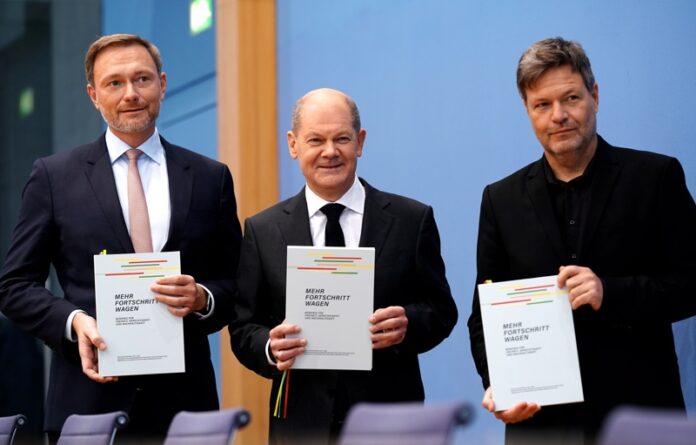 Бъдещият канцлер Олаф Шолц, избраният за министър на финансите Кристиан Линднер и назначеният министър по икономическите въпроси и климата Роберт Хабек позират след подписването на коалиционното споразумение