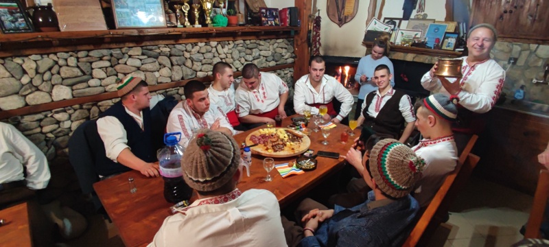 Младите мъже ,които ще влязат в ледените води на Тунджа за традиционното "Ледено хоро" в Калофер, се подгряват с руйно вино и песни.