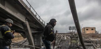 Украински военни вървят по мост, разрушен от обстрела в град Ирпин, област Киев, Украйна, 03/03/22