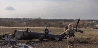Украински войник до разрушен руски хеликоптер близо до Харков, Украйна