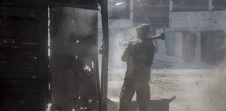 Украински военнослужещ стреля по позиция в град Северодонецк, Луганск, Украйна, 19 юни 2022 г.