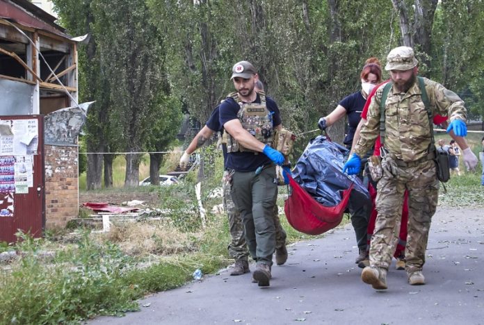 Медици носят тяло на жена след руски ракетен удар по Харков, Украйна, 07 юли 2022 г.