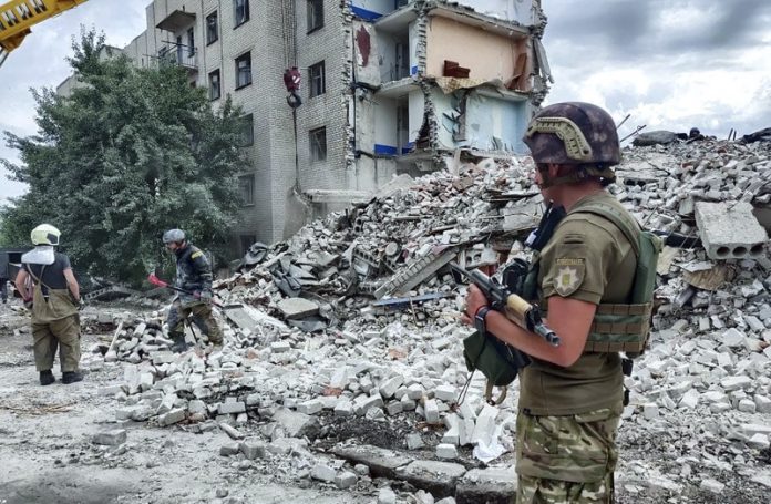 Украински спасители почистват отломките на жилищна сграда след обстрел в Часов Яр, Украйна, 10 юли 2022 г.