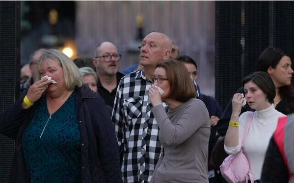  Хора плачат, до момента в който следят процесията с ковчега на кралица Елизабет II 