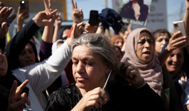 Жена отрязва косата си по време на протест заради смъртта
