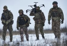 Украински военнослужещи носят дрон