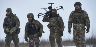 Украински военнослужещи носят дрон