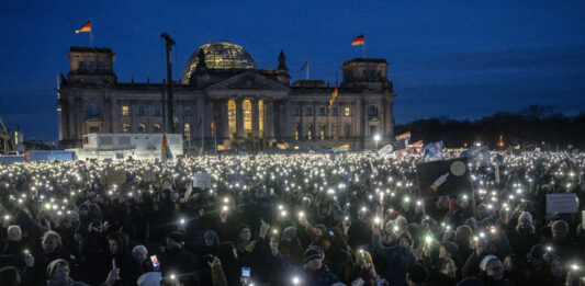 Демонстранти са включили фенерчетата на мобилните си телефони в знак на протест срещу крайната десница в Германия пред сградата на Райхстага в столицата Берлин, 21 януари 2024 г.