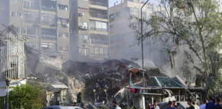 Хора са се събрали край разрушаната сграда на консулството на Иран в сирийската столица Дамаск