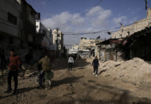 Палестинци се разхождат по повреден път в бежанския лагер "Дженин" на Западния бряг