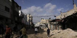 Палестинци се разхождат по повреден път в бежанския лагер "Дженин" на Западния бряг