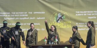 Четирите израелски заложнички на подиума на площад "Палестина" в град Газа, заобиколени от въоръжени бойци на палестинската групировка "Хамас", малко преди да бъдат предадени на Международния комитет на Червения кръст.