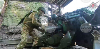 Руски войник подготвя полево оръдие „Хиацинт-Б“ за стрелба срещу украинска позиция