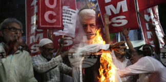 Активисти от синдикални и фермерски организации изгарят чучело с облика на Тръмп на протест срещу митата в Колката, 13 август 2025 година.