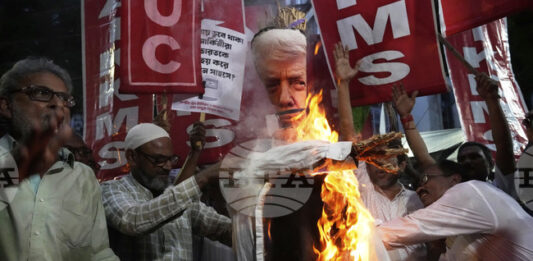 Активисти от синдикални и фермерски организации изгарят чучело с облика на Тръмп на протест срещу митата в Колката, 13 август 2025 година.