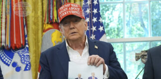 Президентът на САЩ Доналд Тръмп държи снимка на себе си с руския президент Владимир Путин в Овалния кабинет на Белия дом.