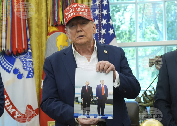 Президентът на САЩ Доналд Тръмп държи снимка на себе си с руския президент Владимир Путин в Овалния кабинет на Белия дом.