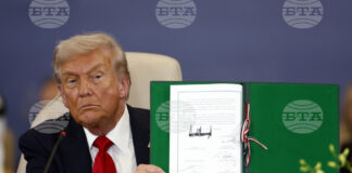 Президентът на САЩ Доналд Тръмп показва подписан документ по време на официална церемония на Международната среща на върха за мир в Газа в Шарм ел Шейх, Египет, 13 октомври 2025 година. Снимка: AP/