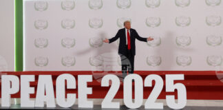 Доналд Тръмп стои на подиум с надпис "Мир 2025" преди началото срещата на световните лидери за прекратяване на войната в Газа