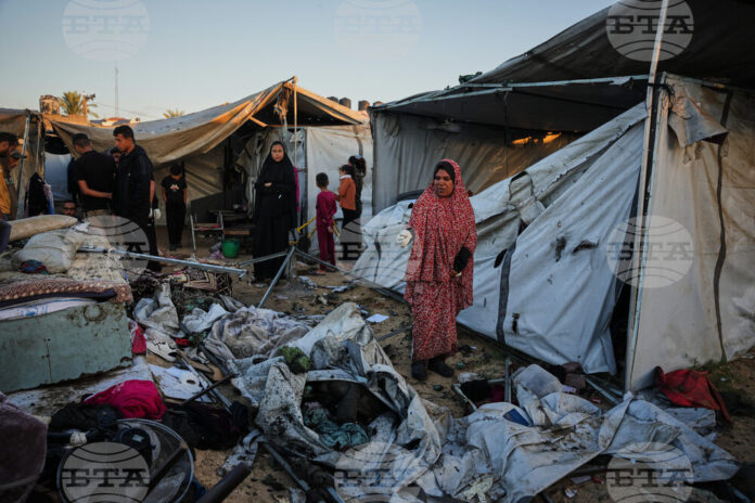 Разселени палестинци оглеждат щетите след израелски военен удар по палатковия им лагер в Дейр ал Балах, ивицата Газа