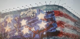 Билборд в центъра на Техеран, на който е изобразен повреден американски самолетоносач и надпис на фарси и на английски: "Ако посееш вятъра, ще пожънеш вихрушката", 25 януари 2026 година.