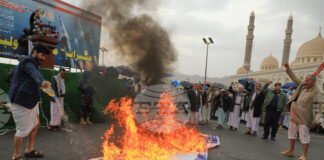Привърженици на хутите горят израелско знаме по време на протест в йеменската столица Сана против войната на Израел и САЩ срещу Иран, 6 март 2026 г.