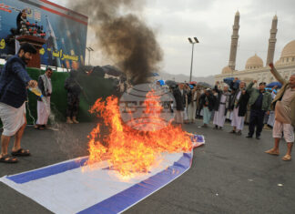 Привърженици на хутите горят израелско знаме по време на протест в йеменската столица Сана против войната на Израел и САЩ срещу Иран, 6 март 2026 г.