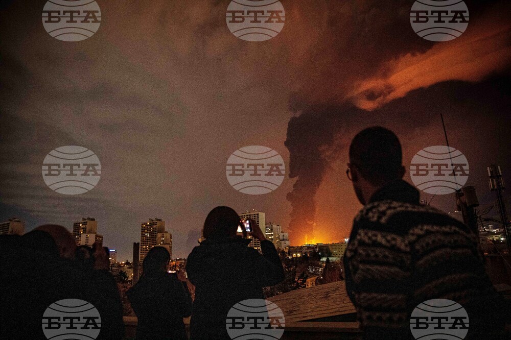 Жители наблюдават пламъци и дим, които се издигат от склад за петрол, поразен при удари срещу Техеран, 7 март 2026 г.