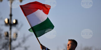 идерът на унгарската опозиция Петер Мадяр развява знамето на Унгария по време на предизборно събитие в Будапеща, 15 март 2026 година.