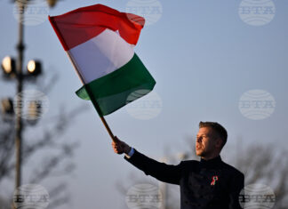 идерът на унгарската опозиция Петер Мадяр развява знамето на Унгария по време на предизборно събитие в Будапеща, 15 март 2026 година.