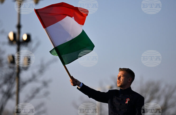 идерът на унгарската опозиция Петер Мадяр развява знамето на Унгария по време на предизборно събитие в Будапеща, 15 март 2026 година.