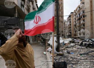 Привърженик на "Хизбула" козирува пред иранското знаме,