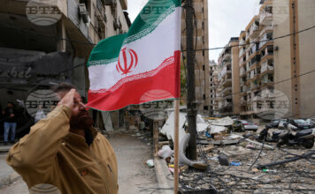 Привърженик на "Хизбула" козирува пред иранското знаме,