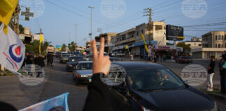 Разселени от войната ливанци се завръщат по селата си, а местни жители развяват знамена на "Хизбула" и плакат с лика на предишния лидер на групировката Хасан Насрала в Южен Ливан след обявяването на прекратяване на огъня между Израел и "Хизбула".