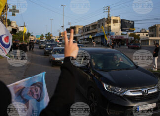 Разселени от войната ливанци се завръщат по селата си, а местни жители развяват знамена на "Хизбула" и плакат с лика на предишния лидер на групировката Хасан Насрала в Южен Ливан след обявяването на прекратяване на огъня между Израел и "Хизбула".