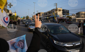 Разселени от войната ливанци се завръщат по селата си, а местни жители развяват знамена на "Хизбула" и плакат с лика на предишния лидер на групировката Хасан Насрала в Южен Ливан след обявяването на прекратяване на огъня между Израел и "Хизбула".