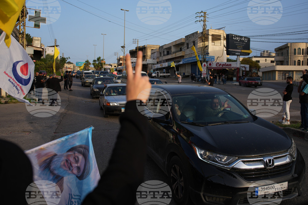 Разселени от войната ливанци се завръщат по селата си, а местни жители развяват знамена на "Хизбула" и плакат с лика на предишния лидер на групировката Хасан Насрала в Южен Ливан след обявяването на прекратяване на огъня между Израел и "Хизбула".