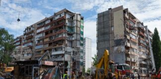 Спасители пред жилищна сграда, повредеена при руски удар в жилищен квартал в Киев, 15 май 2026 година