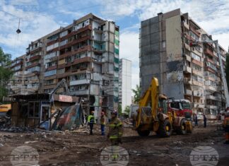Спасители пред жилищна сграда, повредеена при руски удар в жилищен квартал в Киев, 15 май 2026 година