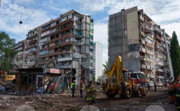 Спасители пред жилищна сграда, повредеена при руски удар в жилищен квартал в Киев, 15 май 2026 година