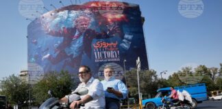 Иранци подминават на мотоциклет билборд в столицата Техеран, изобразяващ президента на САЩ Доналд Тръмп потънал сред експлозии с надпис "Голяма победа! Ормузкият проток", 24 август 2026 г.