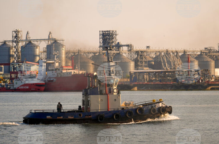 Баржа плава на фона на повреден склад след самодетонацията на морски дрон, използван в конфликта в Украйна, в черноморското пристанище Констанца, Румъния,